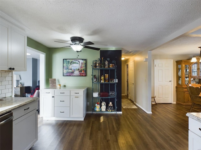 kitchen featuring dark hardwood / wood-style floors, backsplash, white cabinets, and dishwashing machine