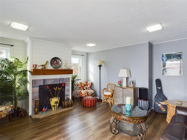 living room with a wealth of natural light, a fireplace, dark hardwood / wood-style flooring, and ornamental molding