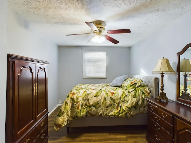 bedroom with ceiling fan, dark hardwood / wood-style flooring, and a textured ceiling