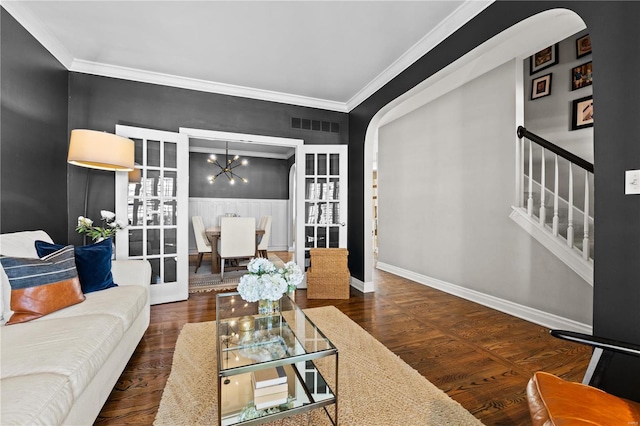 living room with ornamental molding, dark wood-type flooring, french doors, and a chandelier