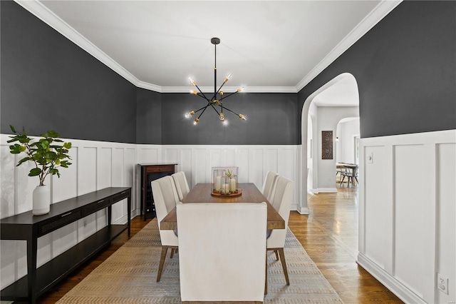 dining space featuring a notable chandelier, hardwood / wood-style flooring, and crown molding