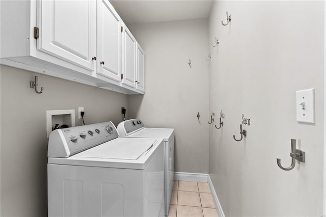 laundry room with light tile patterned flooring, separate washer and dryer, and cabinets