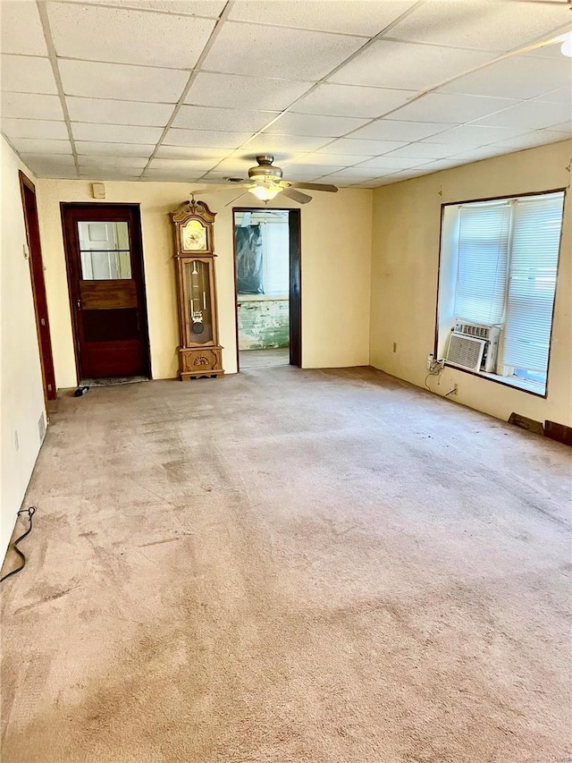 unfurnished living room featuring a drop ceiling, cooling unit, light carpet, and ceiling fan