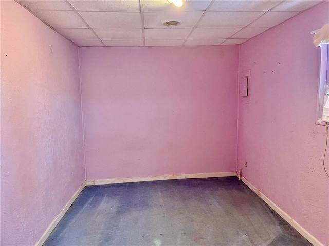 unfurnished room featuring a paneled ceiling and concrete floors