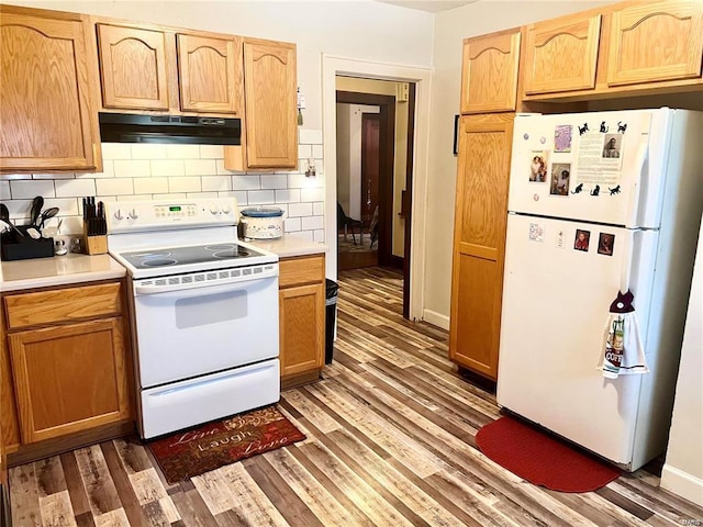 kitchen with white appliances, tasteful backsplash, and dark wood-type flooring