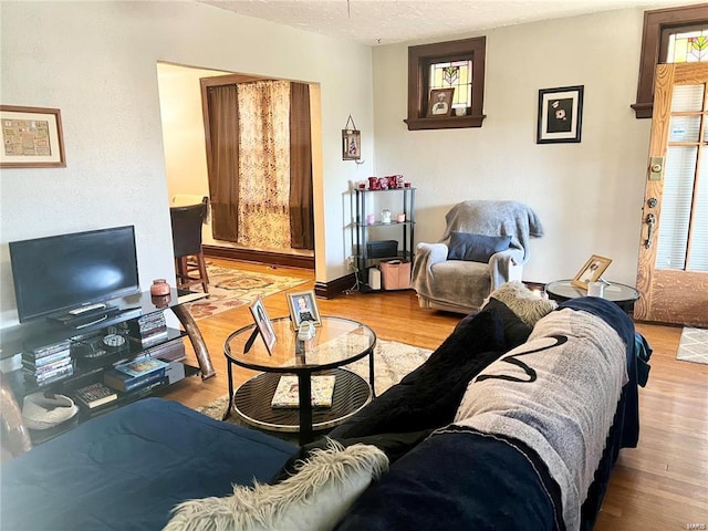 living room with a textured ceiling and light wood-type flooring