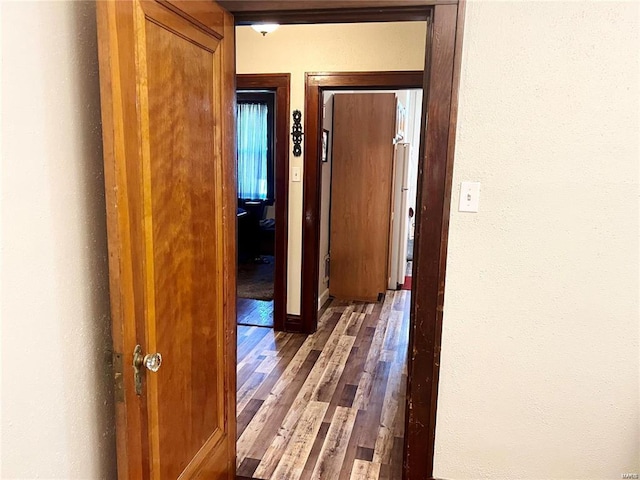 corridor with hardwood / wood-style flooring