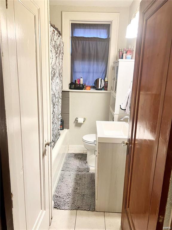 full bathroom with tile patterned flooring, vanity, shower / tub combo, and toilet