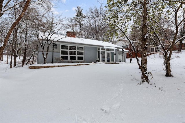 view of snow covered rear of property