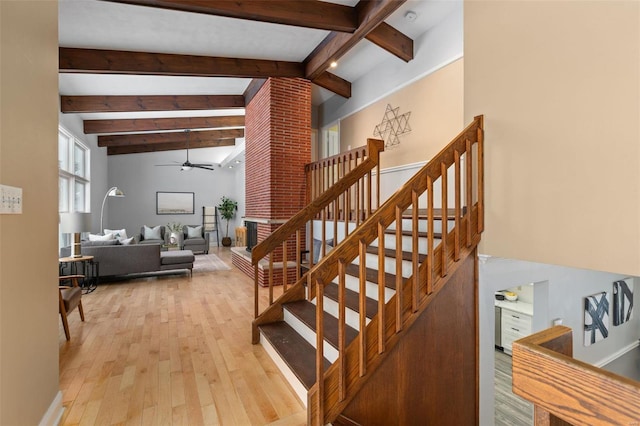 staircase with hardwood / wood-style flooring, ceiling fan, and lofted ceiling with beams