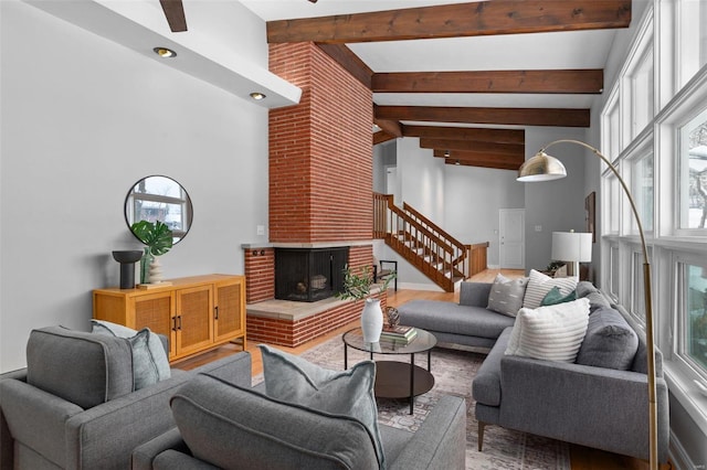 living room with a fireplace, beam ceiling, and a wealth of natural light