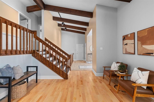 foyer with light hardwood / wood-style floors, high vaulted ceiling, and beamed ceiling