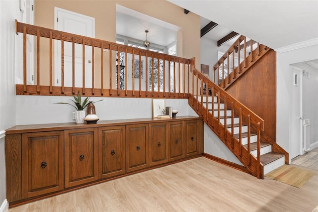 stairway featuring wood-type flooring and ornamental molding