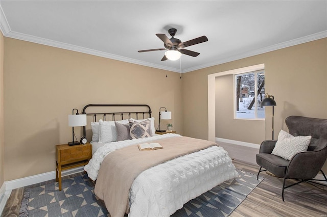 bedroom with ornamental molding, ceiling fan, and wood-type flooring