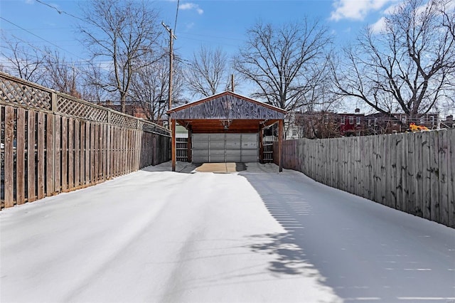 yard covered in snow with an outdoor structure and a garage