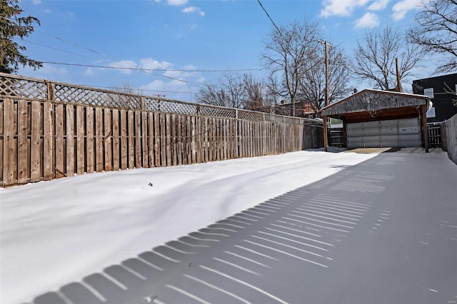 yard covered in snow with a garage and an outbuilding