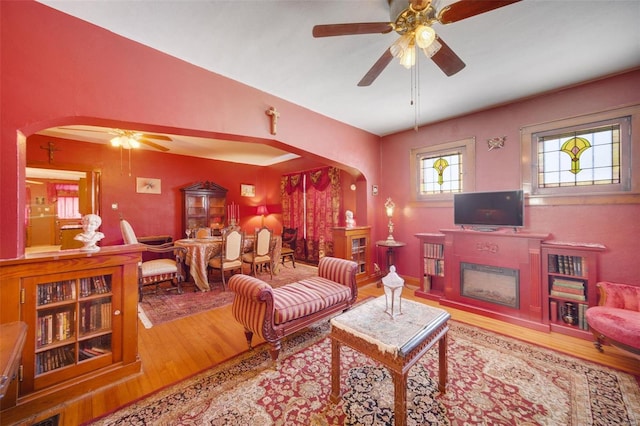 living room featuring wood-type flooring and ceiling fan