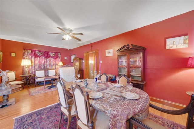 dining area featuring wood-type flooring and ceiling fan