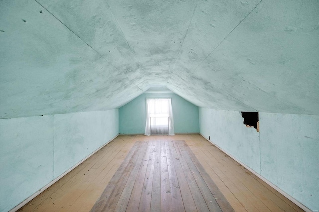 bonus room featuring vaulted ceiling and light hardwood / wood-style flooring