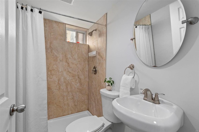 bathroom featuring sink, toilet, and a shower with curtain