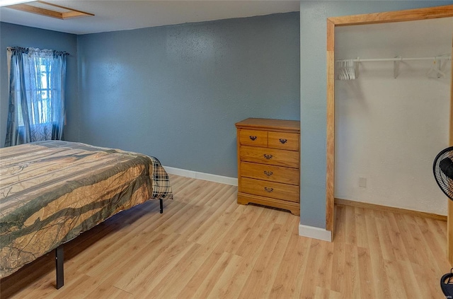 bedroom with light wood-type flooring and a closet