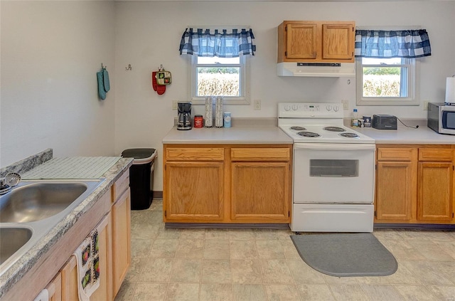 kitchen featuring electric range, plenty of natural light, and sink