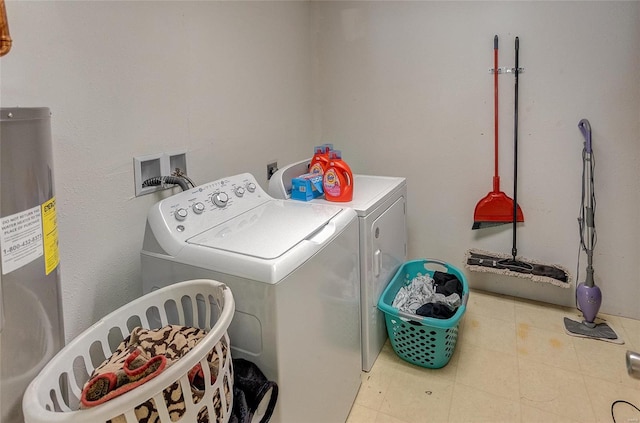 washroom with washing machine and dryer and water heater