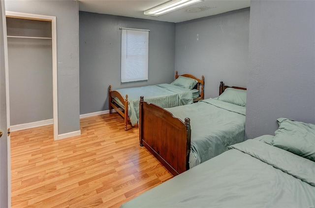 bedroom with light hardwood / wood-style flooring and a closet