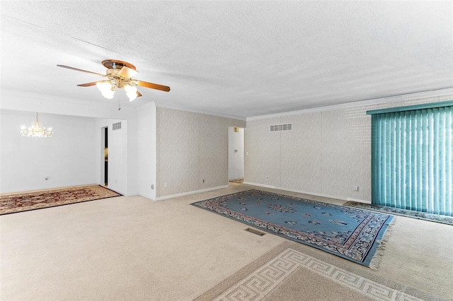 empty room featuring ceiling fan with notable chandelier, a textured ceiling, carpet floors, and ornamental molding