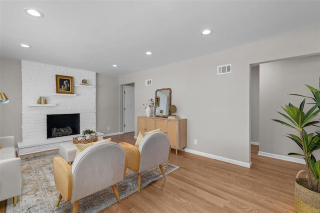 living room with a fireplace and light hardwood / wood-style flooring