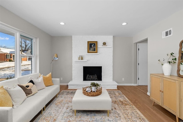 living room featuring light hardwood / wood-style flooring and a fireplace