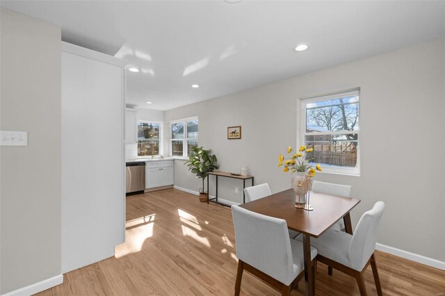 dining space featuring light wood-type flooring and a healthy amount of sunlight