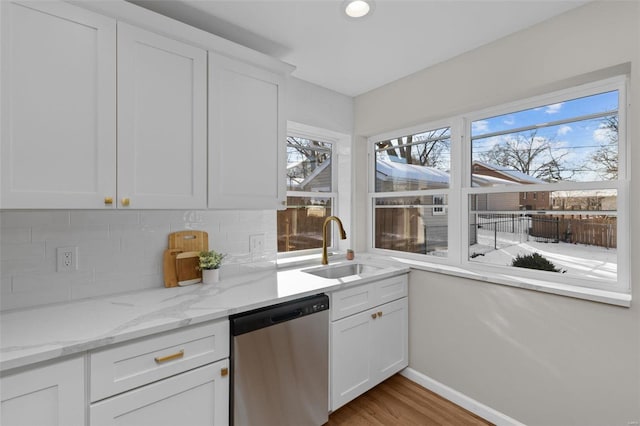 kitchen featuring dishwasher, sink, white cabinetry, and plenty of natural light