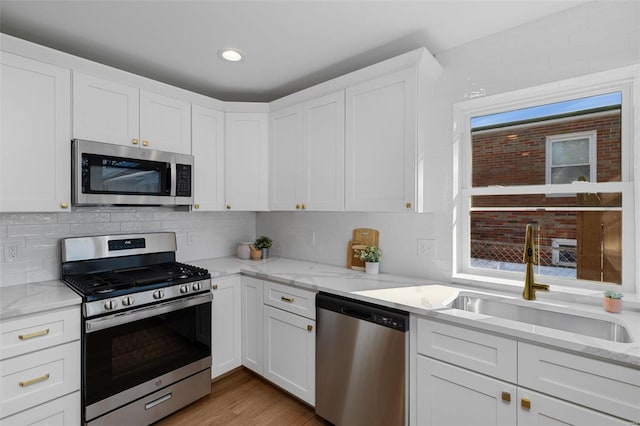 kitchen with a wealth of natural light, white cabinetry, and stainless steel appliances