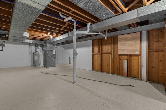 basement with water heater, heating unit, and wood walls