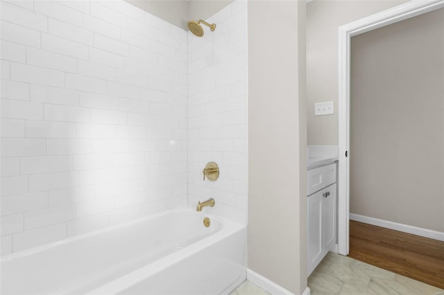 bathroom with tiled shower / bath combo and vanity