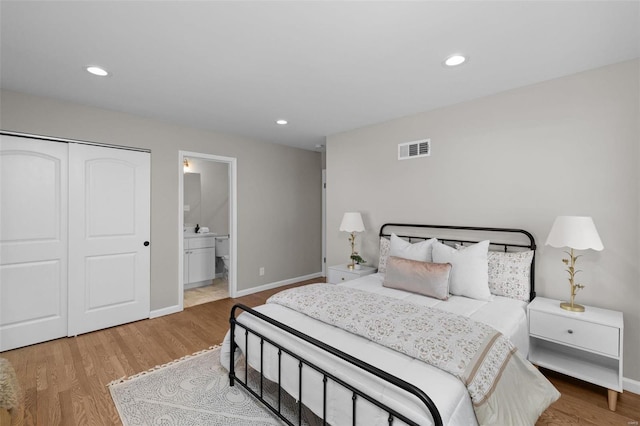 bedroom featuring ensuite bathroom, a closet, and wood-type flooring