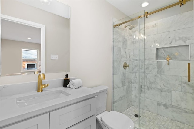 bathroom featuring toilet, a shower with door, and vanity