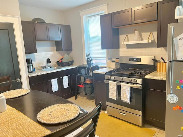 kitchen with a wealth of natural light, dark brown cabinets, sink, and appliances with stainless steel finishes