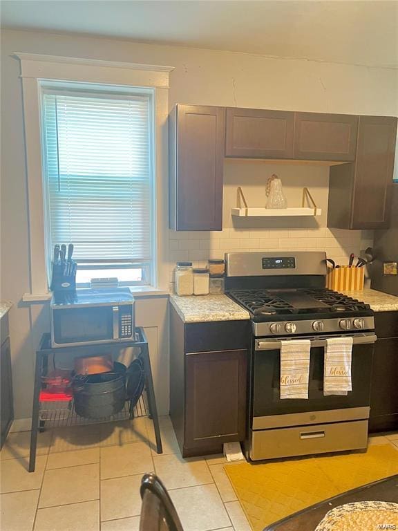 kitchen featuring backsplash, stainless steel gas stove, and light tile patterned floors