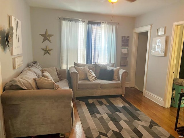 living room featuring ceiling fan and dark wood-type flooring