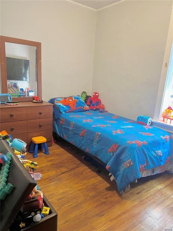 bedroom featuring crown molding and light hardwood / wood-style flooring