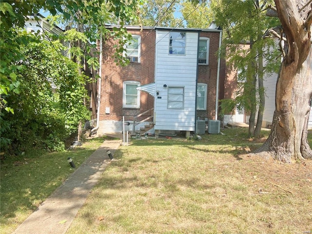 back of house featuring a lawn and central AC unit