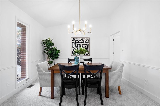 carpeted dining room featuring a wealth of natural light and a notable chandelier