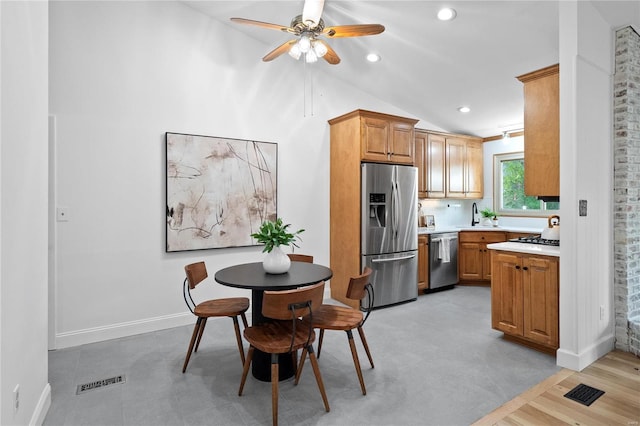 kitchen featuring ceiling fan, sink, vaulted ceiling, and appliances with stainless steel finishes