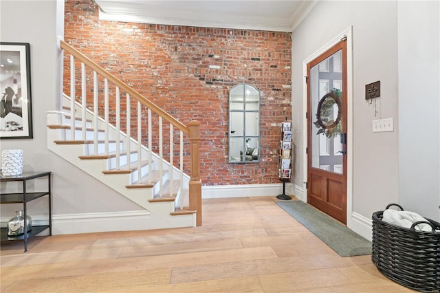 foyer with crown molding and light hardwood / wood-style flooring