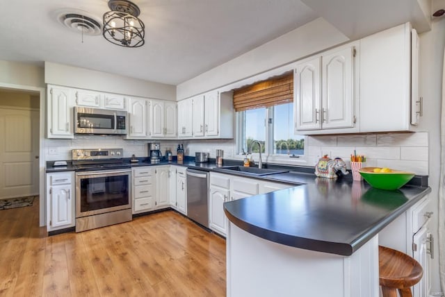 kitchen with white cabinets, decorative backsplash, sink, and appliances with stainless steel finishes