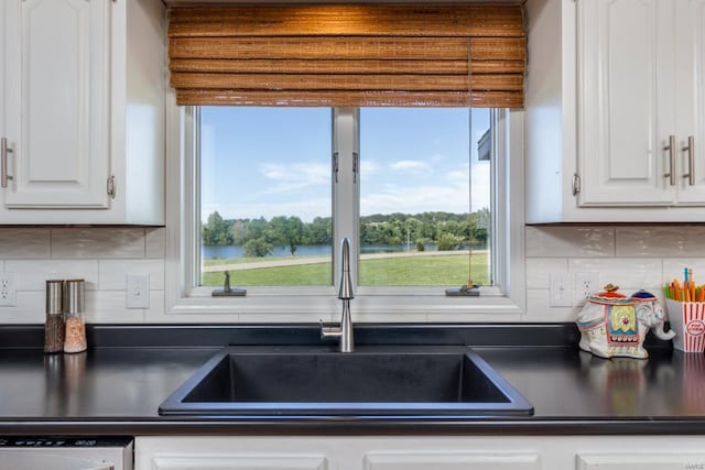 kitchen featuring decorative backsplash, white cabinetry, sink, and dishwasher