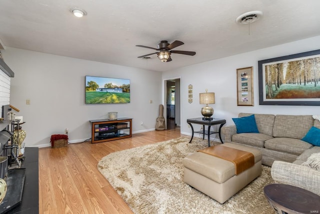 living room featuring ceiling fan and hardwood / wood-style flooring