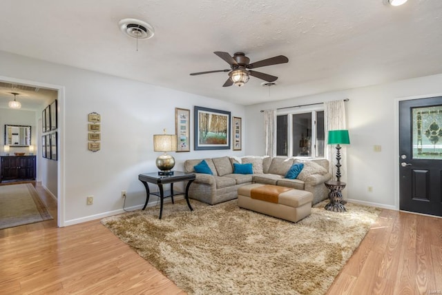 living room featuring wood-type flooring and ceiling fan